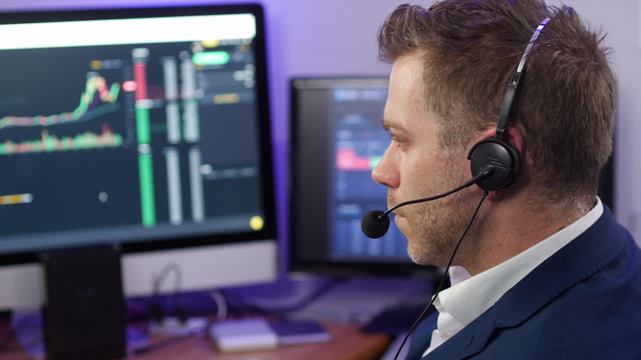Nodding man in business clothing working in technical support at a trading broker desk with computers