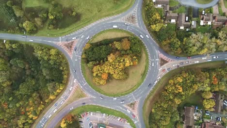aerial traffic rotating above urban roundabout traffic top down view