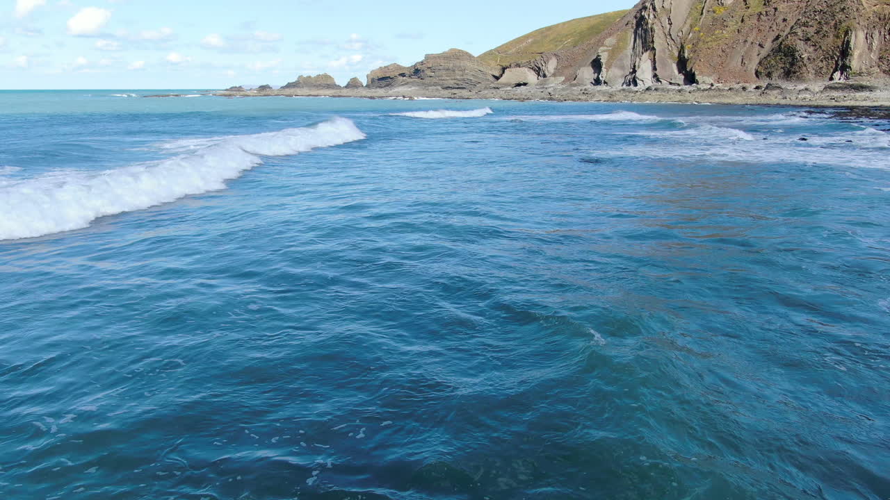 toma aérea de las olas en el mar azul en la playa costera de spekes mill en devon