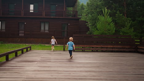 toddler boy runs follows elder sister jumping down from deck