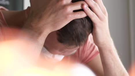 man rubs his hands on his head in despair, wearing face mask covid coronavirus