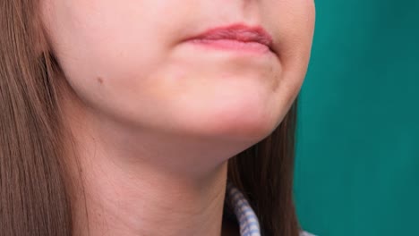 close up of a female biting a burger on a green screen. the concept of unhealthy nutrition and diet