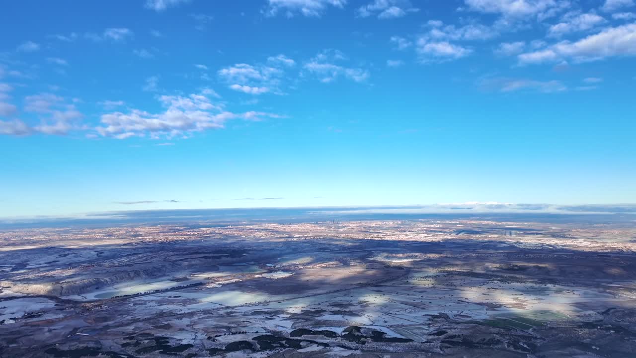 Cockpit view captured from an airplane cockpit approaching to Madrid airport (MAD) with a far view of the city and the airport runway ahead under a blue clear sky