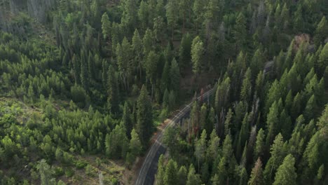 drone footage of a windy mountain road in the sawtooth mountains with a car driving