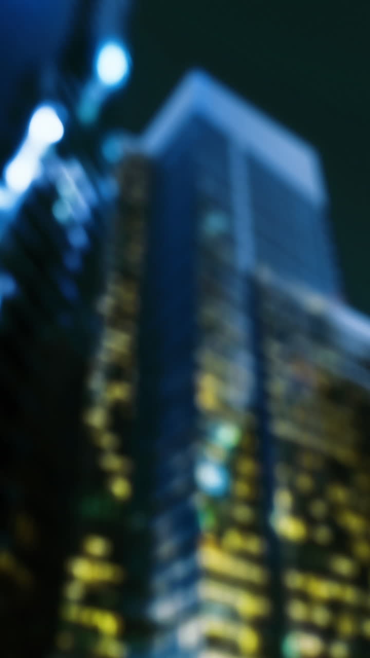 City skyline illuminated at night with modern buildings reflecting lights