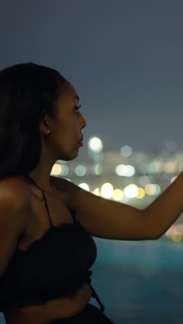 woman photographing a city skyline at night with her smartphone