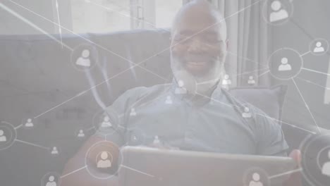 animation of networks of connections with icons over man using tablet