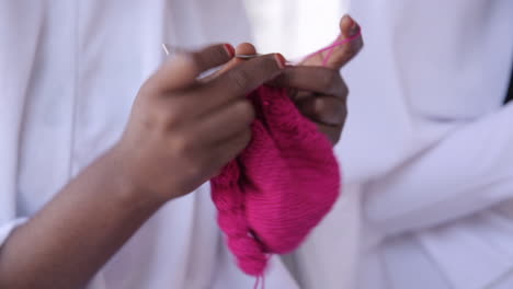 hands of a nigerian woman knitting very fast