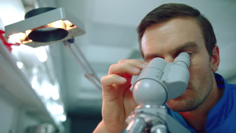 male doctor microscope. close up of doctor scientist looking through microscope