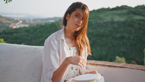 embroidery lady enjoying hobby at summer balcony portrait. woman looking camera