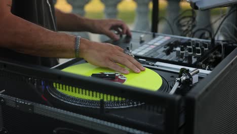 Nahaufnahme-Eines-Hochzeits-DJ-Mannes,-Der-Den-Controller-Mit-Gelbem-Vinyl-Spielt-Und-Einstellt