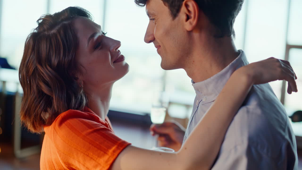 Romantic couple dancing together drinking champagne in home interior closeup