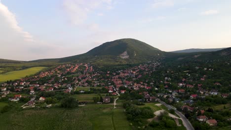 drone flying towards small hungarian village at the base of the pilis mountain