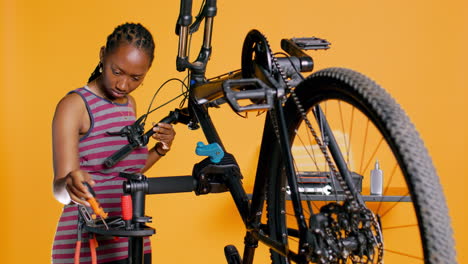 expert uses screwdriver to tighten brake levers on bicycle, examining components