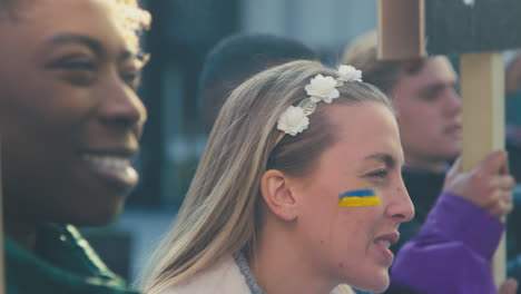 group of protestors with placards on ukrainian anti war demonstration march