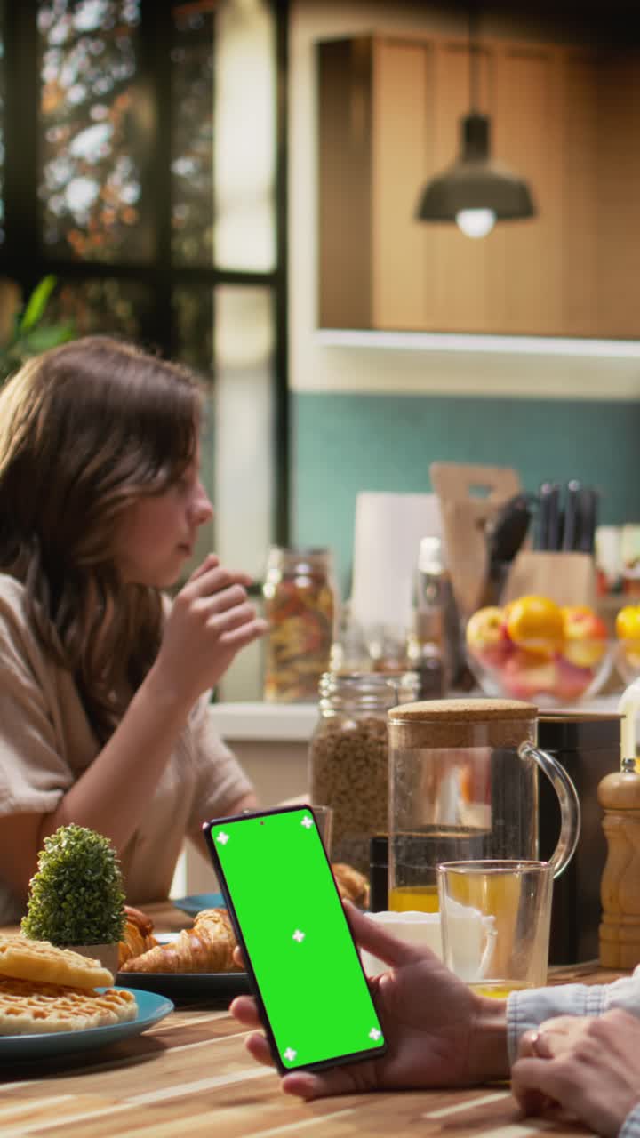 Vertical Video Vertical green screen smartphone held by mom serving breakfast with daughter