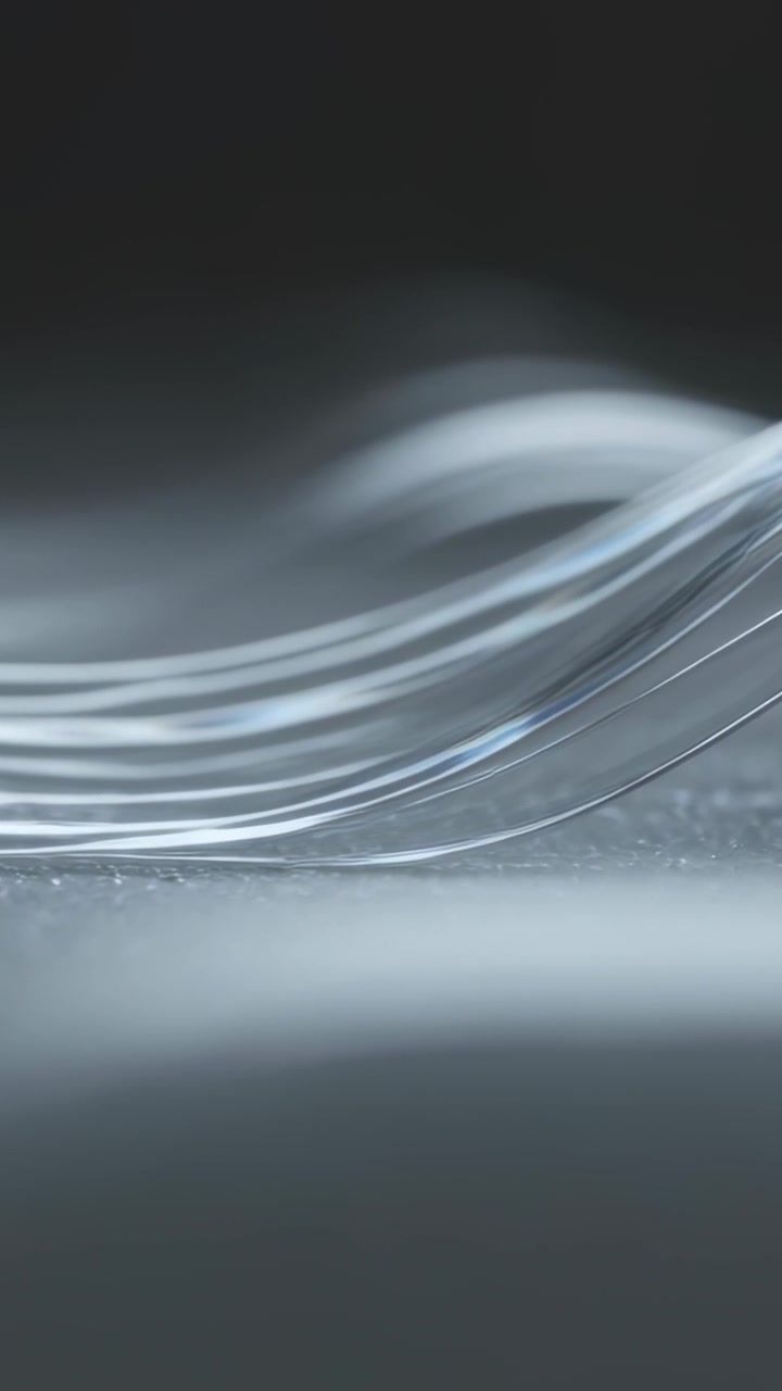 Vertical video: Lifting thin filaments during playback in studio into crest on mat, catching light
