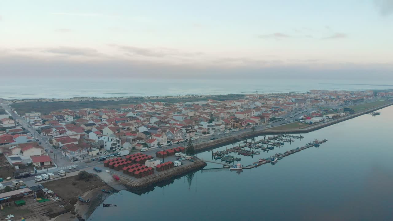 Vista aerea di un piccolo villaggio tra l'oceano e il fiume in una giornata nuvolosa