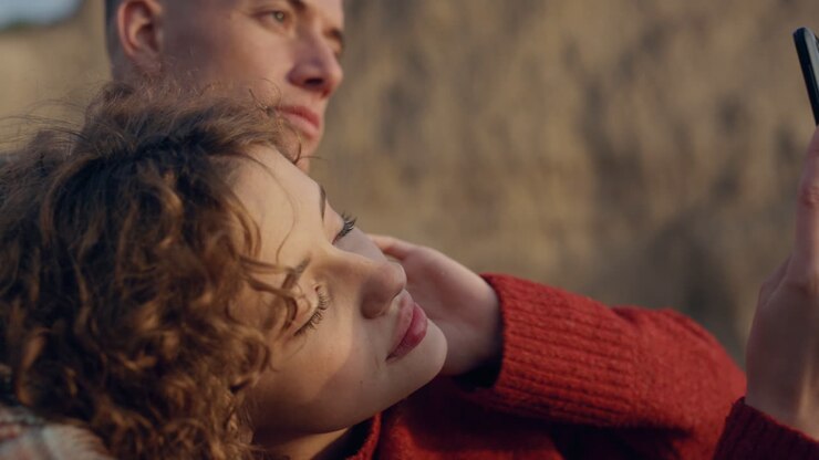 Donna e uomo romantici che si scattano un selfie in spiaggia. Coppia che si gode il tempo insieme.