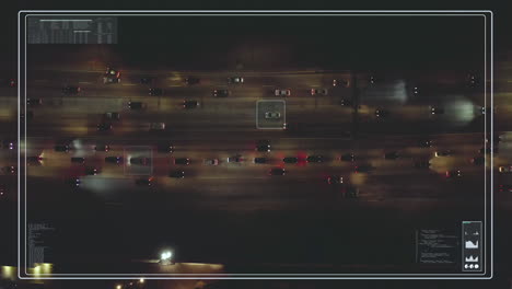 Top-down-footage-of-traffic-on-busy-multilane-road-in-city-at-night.-Futuristic-visual-effect-tracking-selected-cars