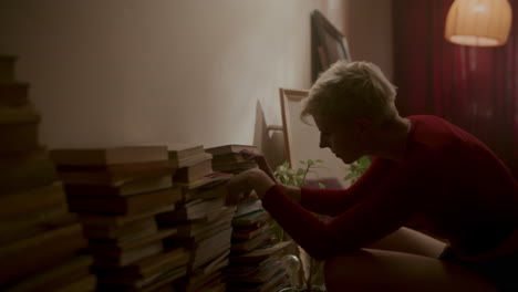 woman interacting with a stack of books