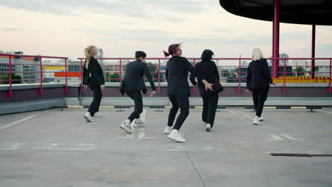 Cheerful-female-dancers-performing-on-a-parking-lot