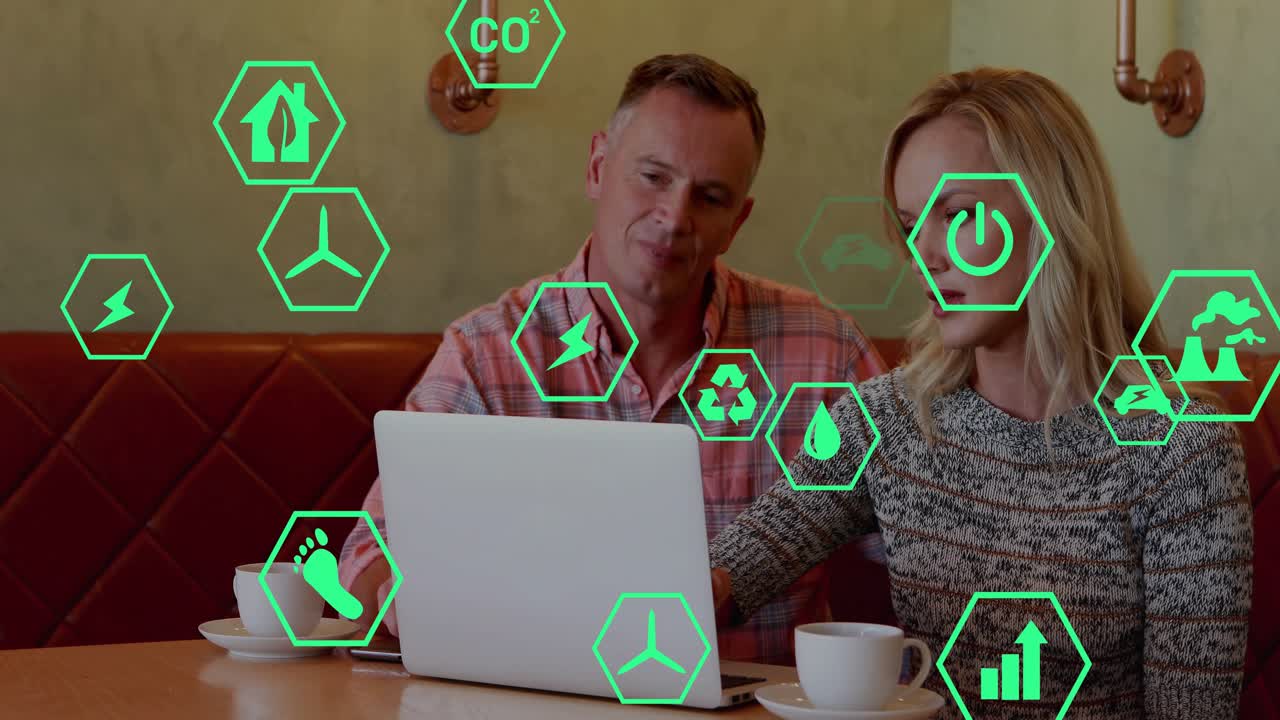 Man and woman opening laptop lid at cafe table activating green hexagon icons reviewing eco metrics