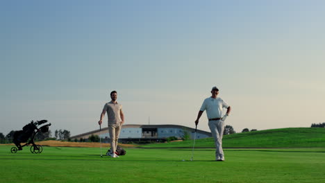 Two-men-enjoy-golf-on-fairway-field-club.-Golfing-team-practicing-play-sport.