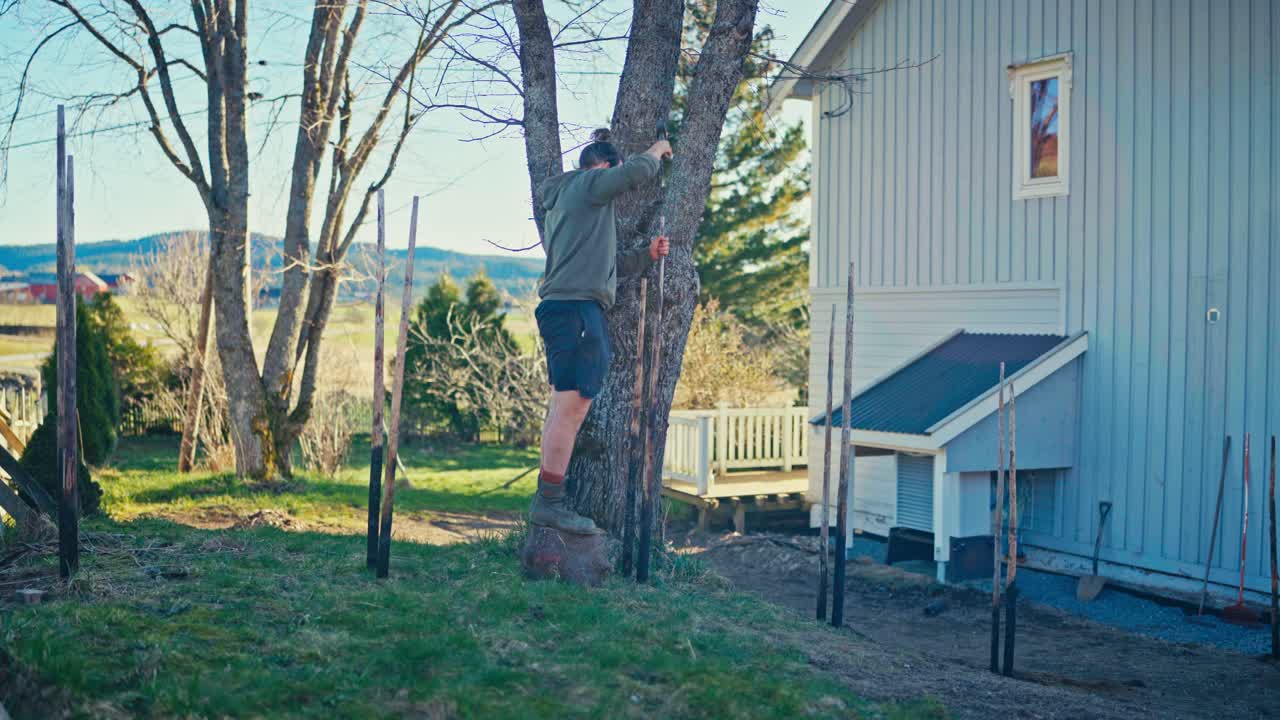 Man Putting Charred Woods Constructing Skigard - Wide Shot