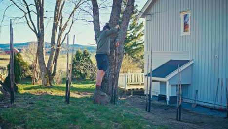 man putting charred woods constructing skigard - wide shot