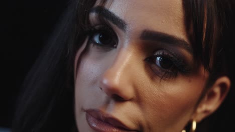 young woman with sweet eyes looks into the camera, close up