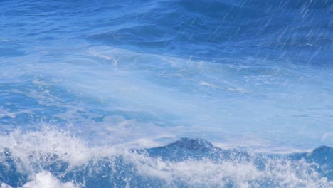 strong ocean swell and waves crashing into shore sending spray and mist into the air