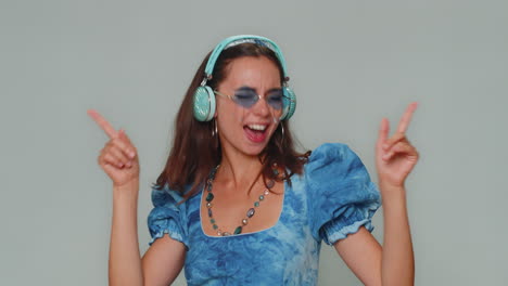 Happy-young-woman-in-blue-princess-dress-listening-music-and-dancing-disco-fooling-around-having-fun