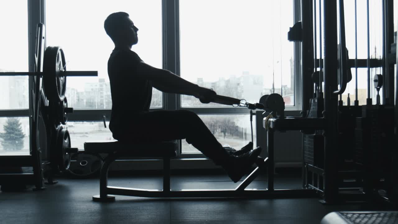 Man Performing Seated Row Exercise in Gym