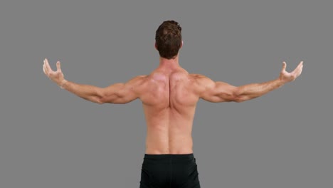 rear view  of muscular man outstretching his arms