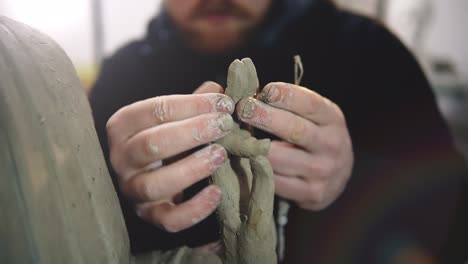 Cropped-view-of-clay-Buddha's-statue-hand,-artist-modeling-hands-using-hands