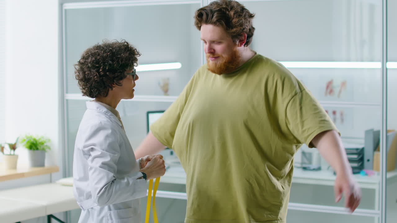 Female Doctor Measuring Waist of Overweight Patient