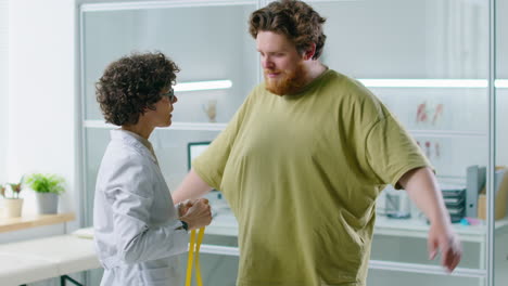 female doctor measuring waist of overweight patient