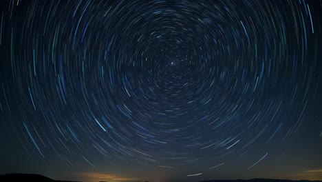 witness mesmerizing star trails creating circular patterns in the night sky above a tranquil landscape.