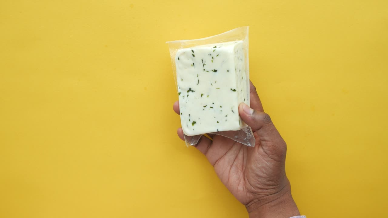 mano con un bloque de queso