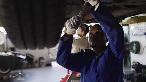 Video-of-african-american-female-car-mechanic-repairing-car