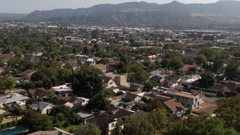 suburb in burbank, california at the base of picturesque and iconic hollywood mountains and foothills - ascending aerial view