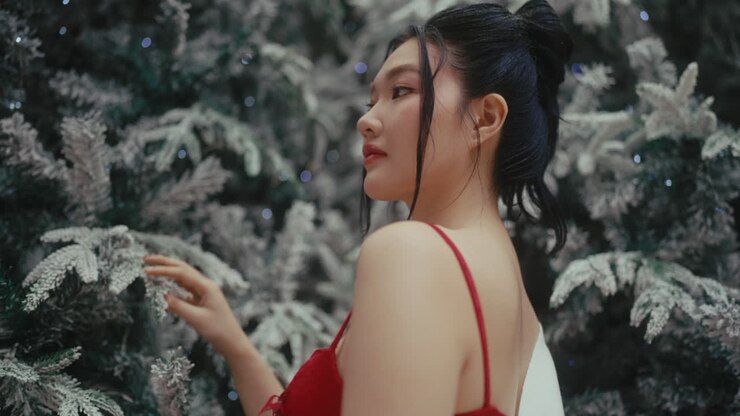 Woman in a Red Dress near a Christmas Tree