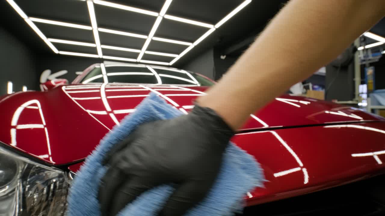 trabajador pulir un coche rojo. detalles del coche - los hombres están usando maquinaria pulidores de automóviles mantenimiento para eliminar marcas reparación de acuerdo con la superficie de la pintura del coche antes de contin