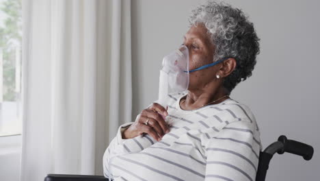 mujer afroamericana anciana en silla de ruedas con máscara de oxígeno, espacio de copia, cámara lenta