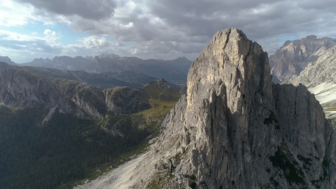 panorámica aérea alrededor de un pico en los dolomitas italianos que revela más en el fondo