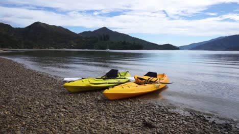 dos kayaks de mar en la playa rocosa en los sonidos de marlborough, nueva zelanda