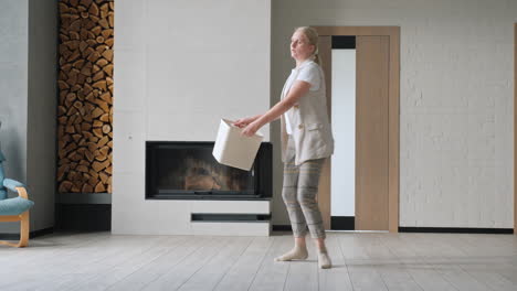 woman carrying box in a modern living room