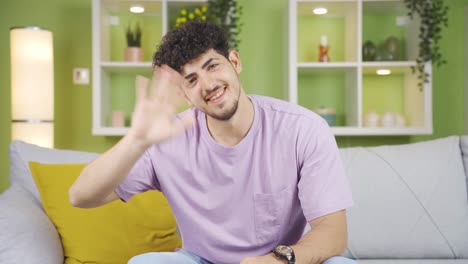 joven agitando mirando a la cámara con alegría y felicidad.