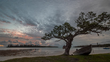 Sonnenuntergang-Im-Zeitraffer,-Mit-Einem-Boot,-Baum,-Meer-Und-Wolken,-Die-Sich-In-Viele-Richtungen-Bewegen